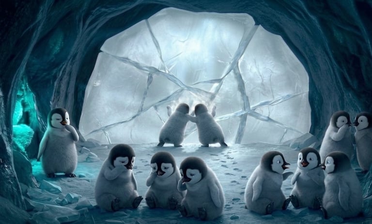 Group of cute animated baby penguins gathered inside a frosty ice cave with glowing blue light.