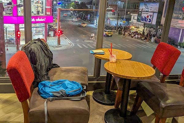 Backpack and laptop at Highland coffeeshop overlooking a city intersection in Da Lat Vietnam