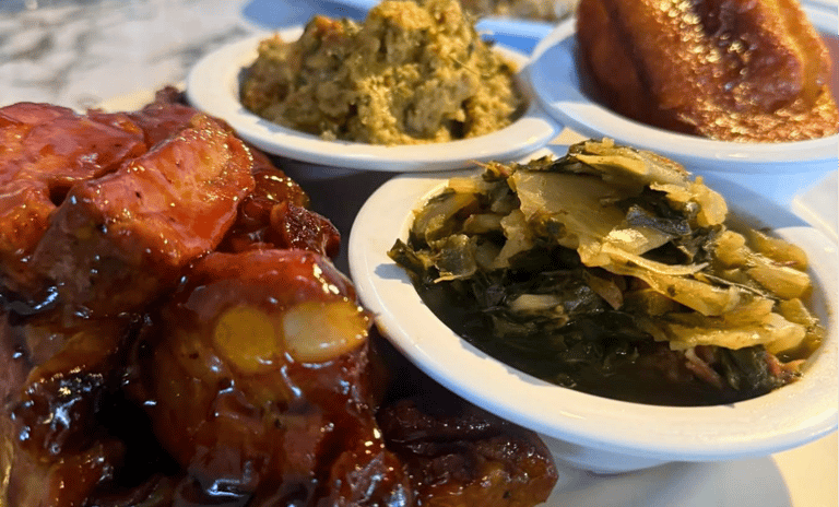 A plate of southern soul food featuring barbecue ribs, collard greens, cornbread, and stuffing.