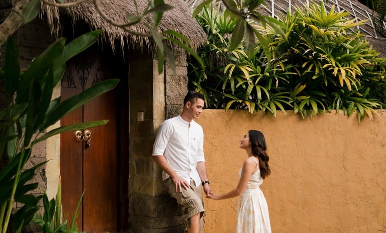 Couple standing at villa entrance surrounded by tropical greenery at Waka Gangga Tabanan