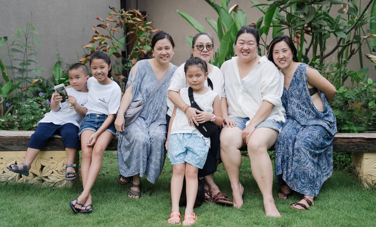 Extended family sitting together during photography session at Lumbini Villas Jimbaran Bali in relaxed garden setting