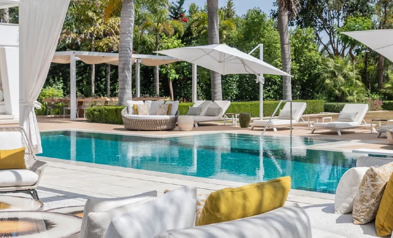 Villa Serenity poolside with daybeds and chic white pergola