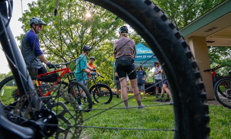 People on bikes in the background of a photo with the focus on a bike tire