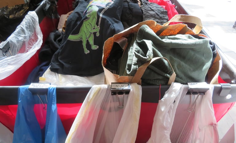 Red bin filled with bags of donations