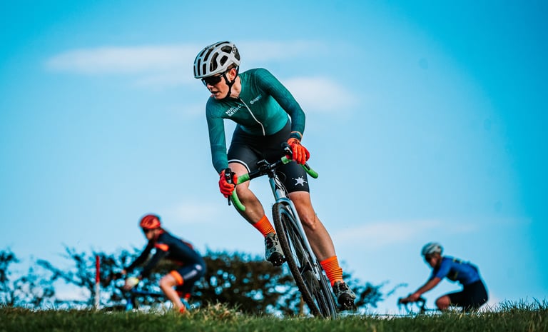 A cyclist turning on a steep bank in a cyclocross race