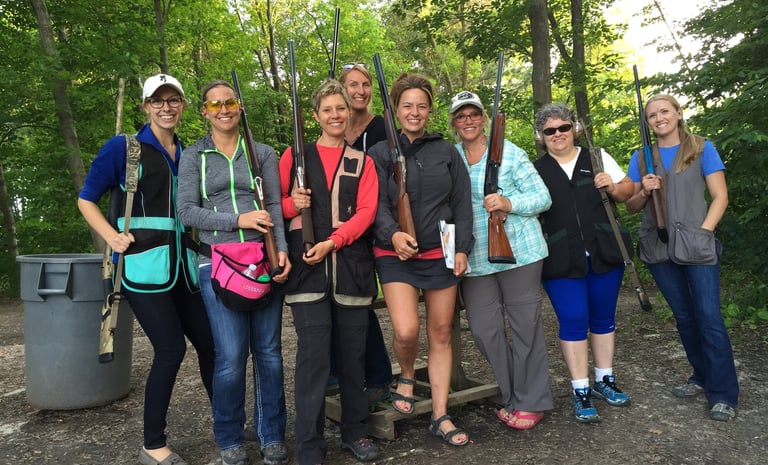 Group of women holding shotguns on sporting clays course.