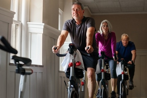 a man and woman riding bikes in a gym