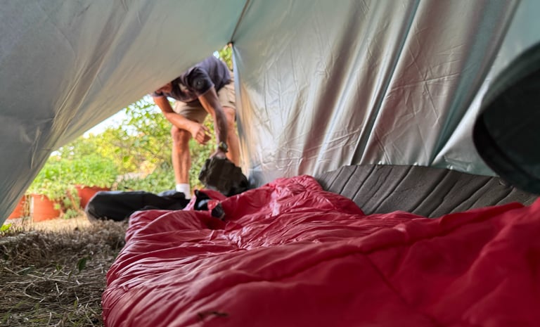 vista interior de un refugio de fortuna construido con un tarp y linea de cordino