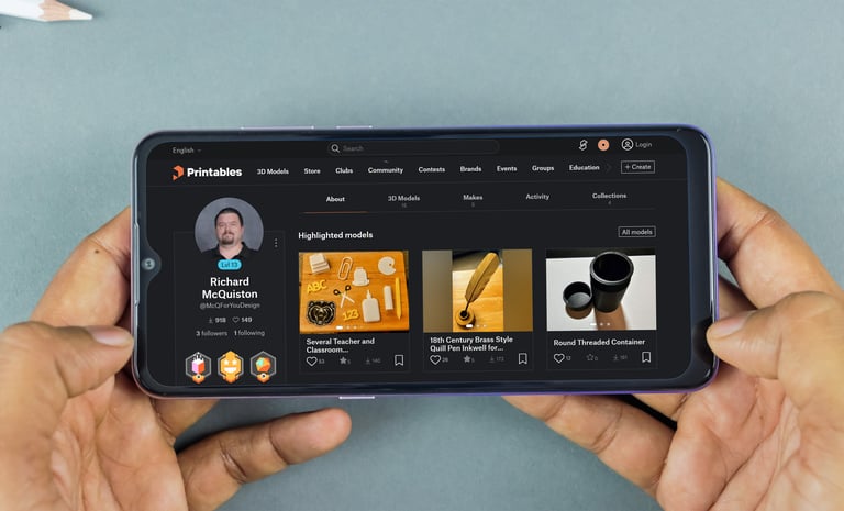 A person holding a smartphone displaying the Printables website with 3D printing models.