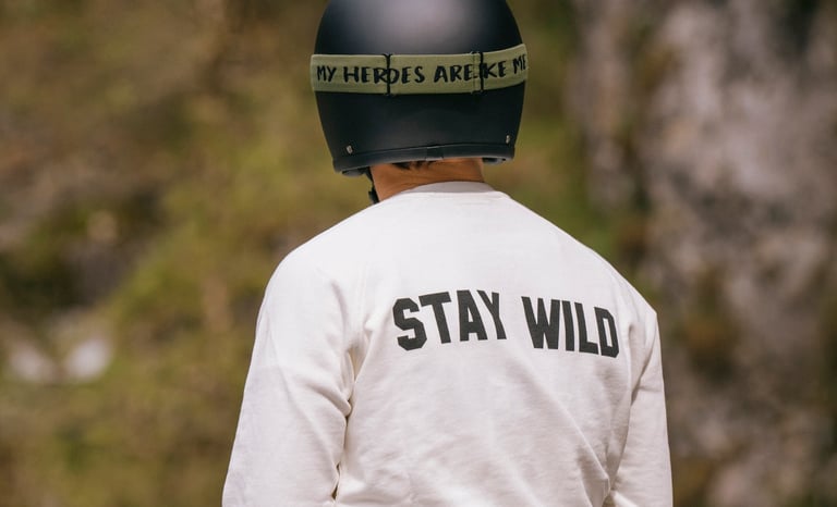 Motocyklista w czarnym kalsycznym kasku, goglach i bluzie STAY WILD