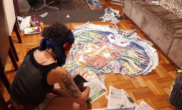 Naía découpe la composition réalisée sur papier journal avant d'aller la coller dans les rues de Belo Horizonte