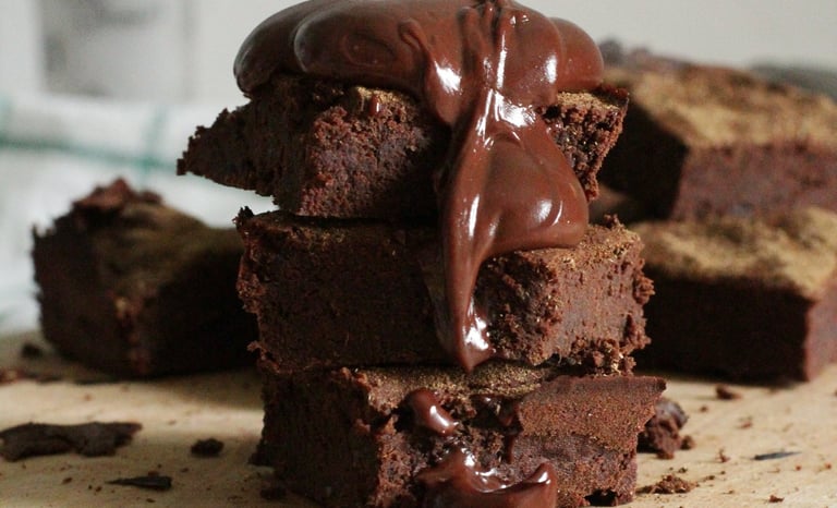 a stack of chocolate brownies with chocolate frosting
