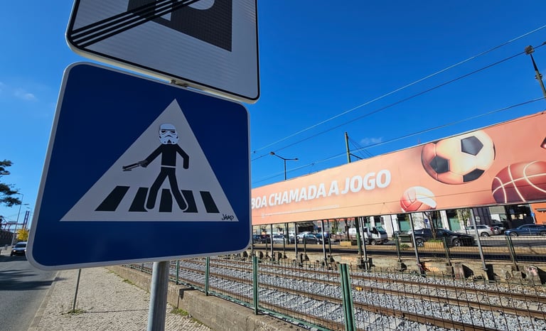 Street art sur panneau de signalisation représentant un Stormtrooper sur un panneau piéton à Lisboa