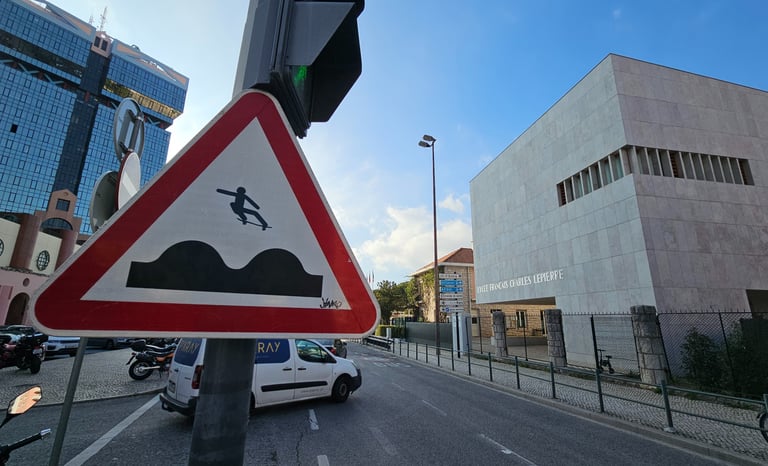 Street art sur panneau de signalisation représentant un skateur sur un dos d'ane à Lisbonne
