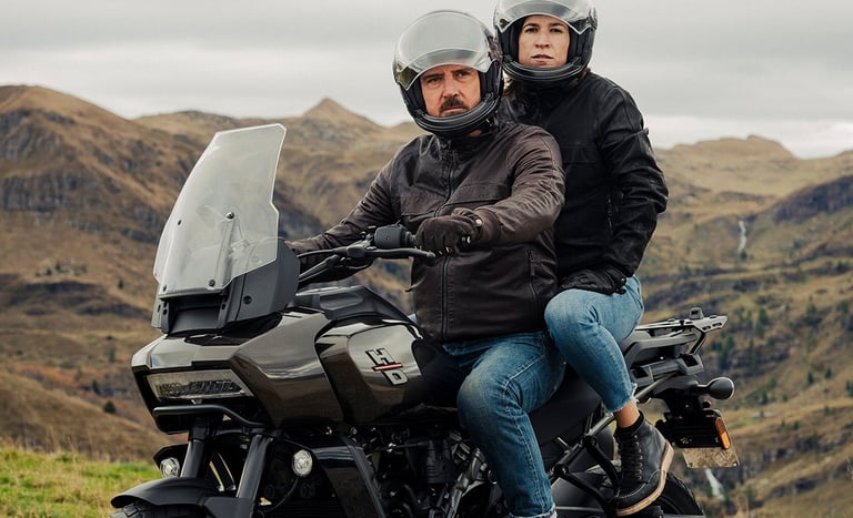 Para siedząca na motocyklu Harley-Davidson Pan America w modułowym kasku motocyklowym marki DMD