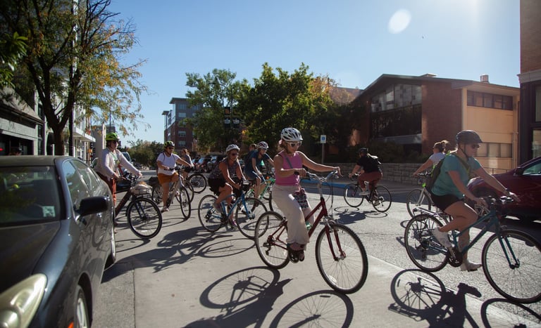 A group of around 10 women riding bikes on a street in downtown Columbia