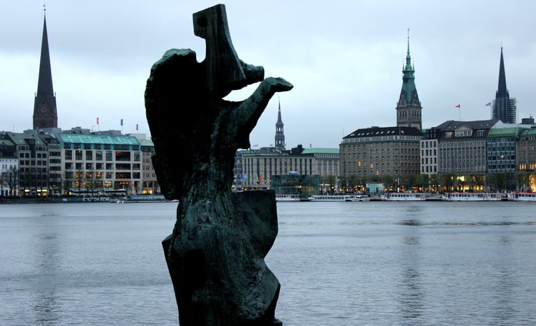 large sculpture overlooking the reservoir in Hamburg among church steeples