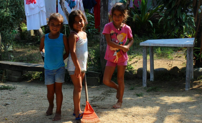 three young children playing with a broom in Puerto Vallarta