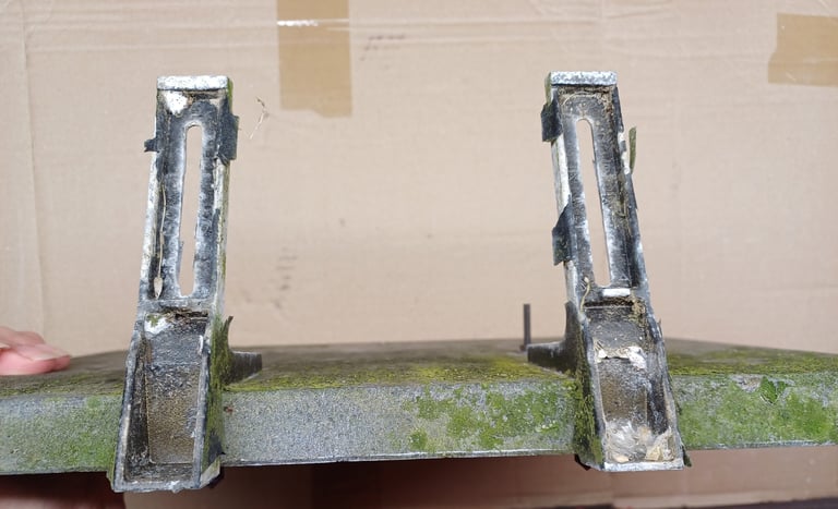 plaque funéraire abimée, mousse, saleté, peinture écaillée