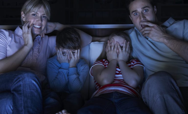 a family sitting on a couch watching tv