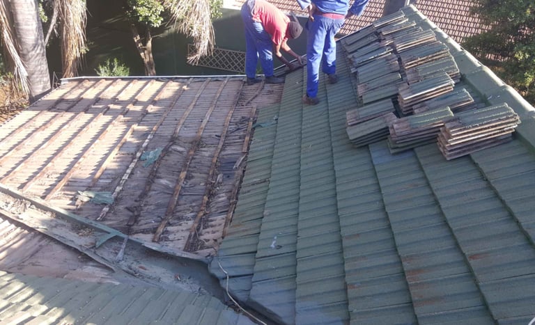 Roof tiles removed to expose damaged battens and waterlogged timber