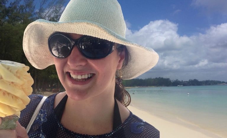 Autora saboreando abacaxi esculpido na praia de Mont Choisy, Port Louis, Ilhas Maurício.