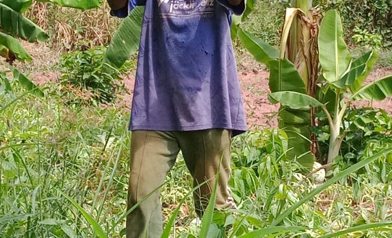 a man holding a watermelon in a field