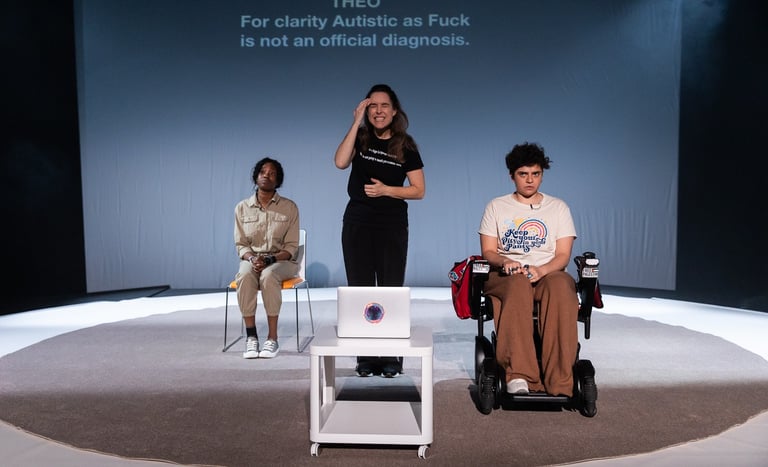 A black woman, a brown electric wheelchair user, and a white woman gathered on a stage