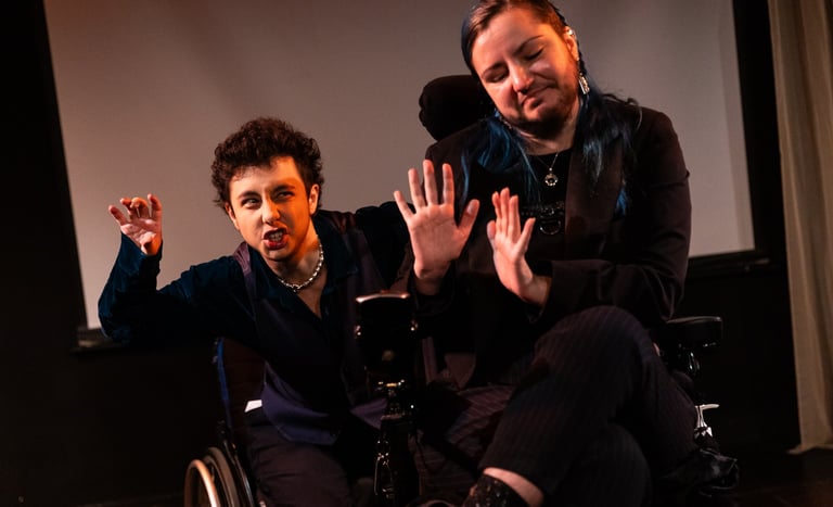 Two people signing BSL, one in a manual and one in an electric wheelchair