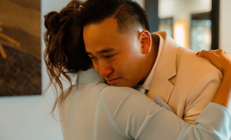 a man in a suit and tie is hugging a woman