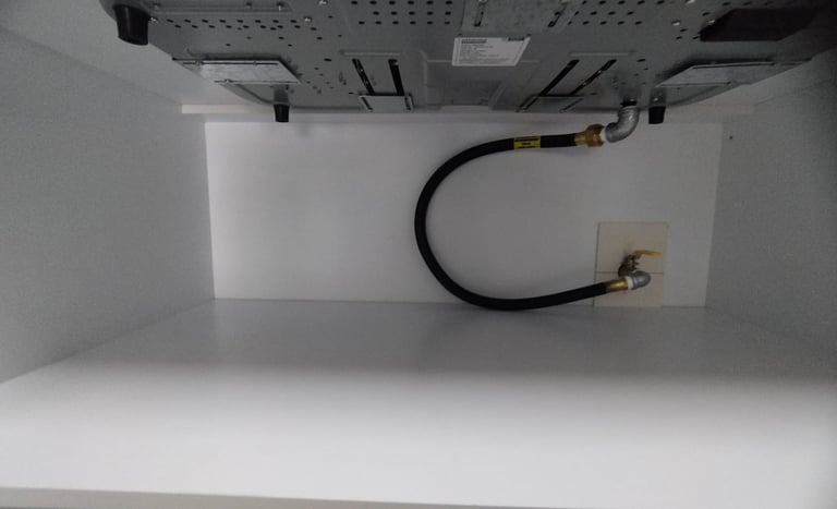 A black flexible gas pipe connecting home appliance with main gas line