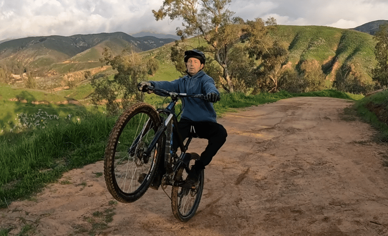 mountain biker practicing using rear brake to keep from looping out on wheelie