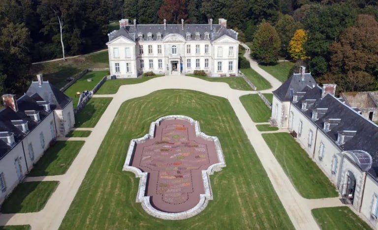 Vue aérienne d'un château français historique avec un jardin à la française et une architecture en p