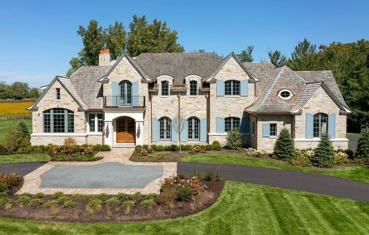 Stone French country custom home with shingle roof in western Chicago suburbs