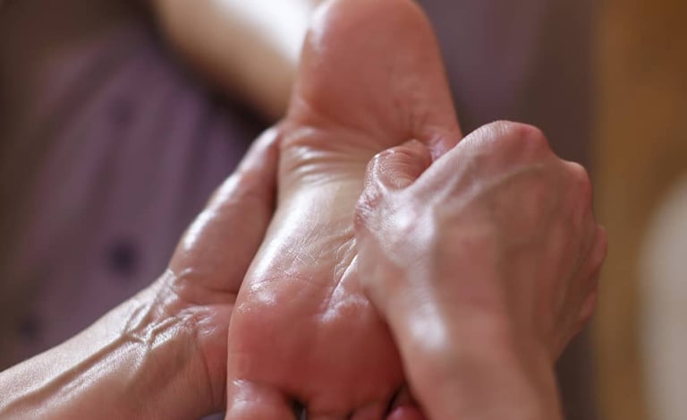 Massage du pied, geste lent et précis pour relâcher les tensions et inviter au lâcher-prise.