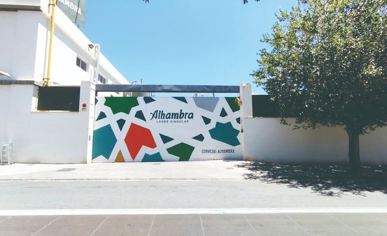 Graffiti mural corporativo en fachada fábrica Cervezas Alhambra. Para la campaña de Grupo Mahou.