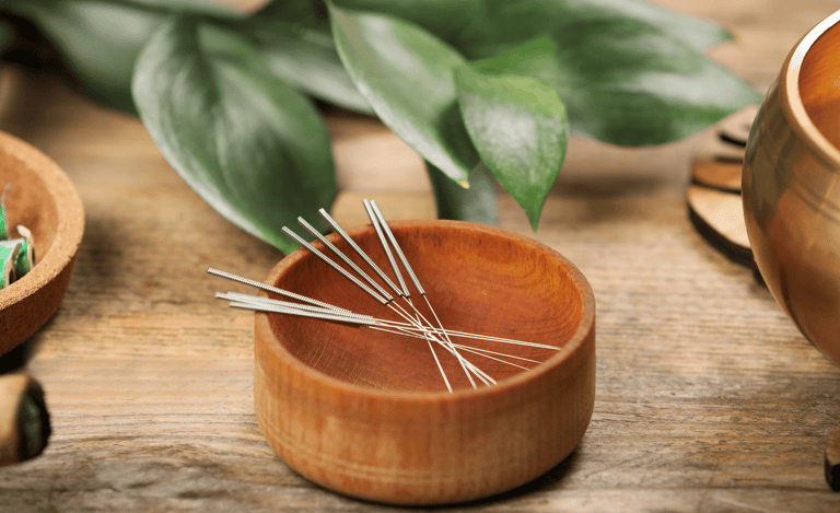 Aiguilles d'acupuncture dans un bol en bois, bol tibétain à coté
