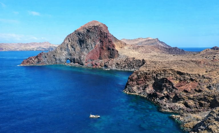 Aerial view of Ponta de São Lourenço volcanic red cliffs, natural arch and turquoise waters, Madeira