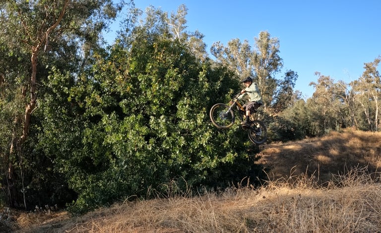 mountain biker performing rear brake tap mid air technique
