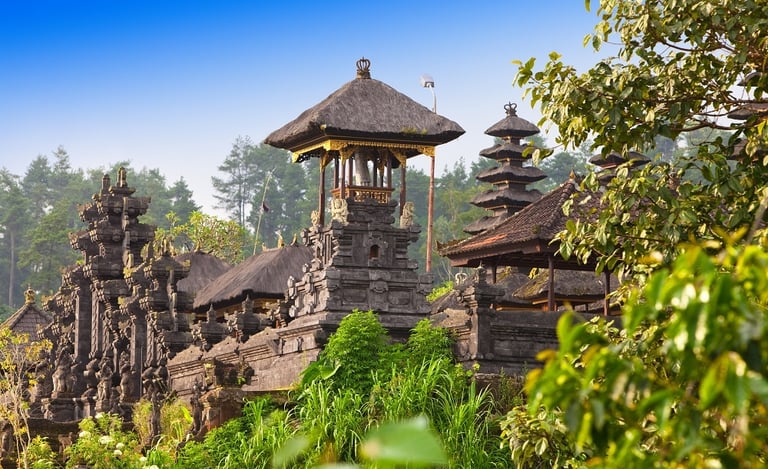 Besakih Temple gates made of black volcanic stone against a clear blue sky