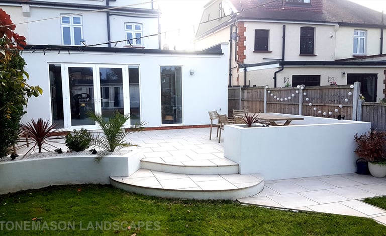 Modern chic raised porcelain patio with white rendered walls and planters