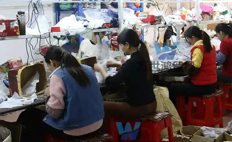 Factory workers on an assembly line packaging goods for export in a manufacturing facility.