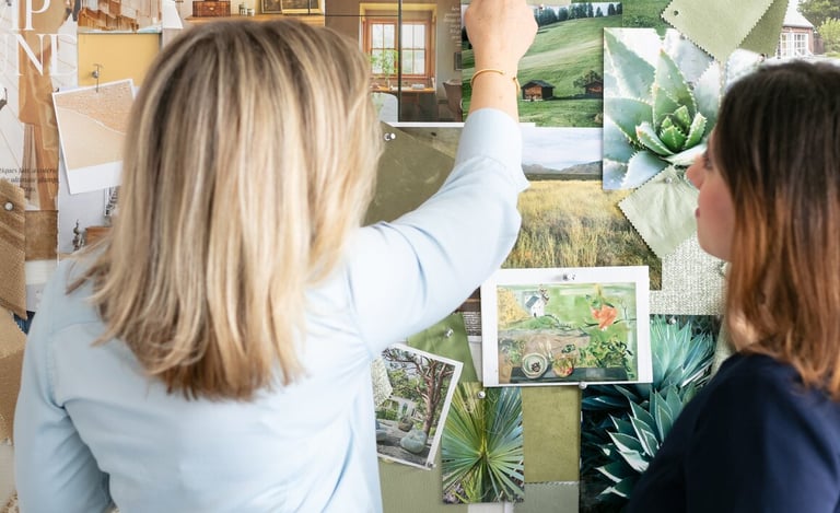 Interior designers review a green mood board with fabric swatches and nature photography for home decor inspiration.