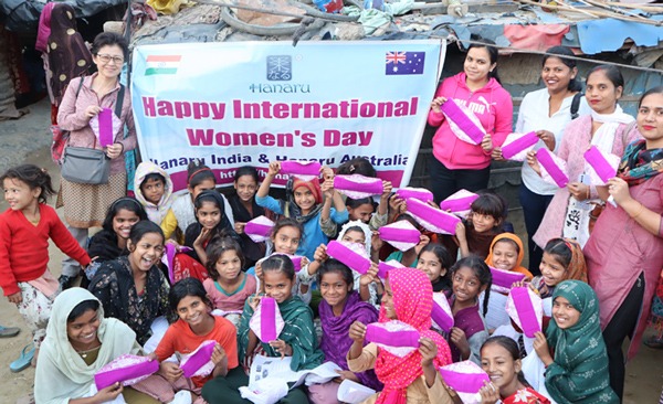 Group of girls and a few women holding up Hanaru's sanitary napkins