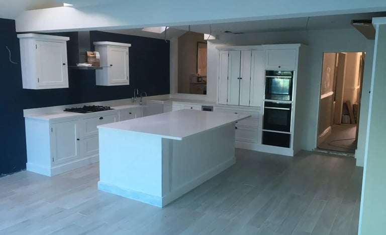Large open-plan kitchen with island and fitted cabinets in renovated Brighton property.
