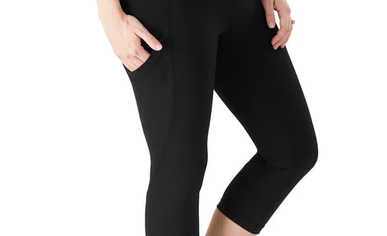 Pregnant woman wearing black maternity capri leggings with side pockets and over-the-belly support.