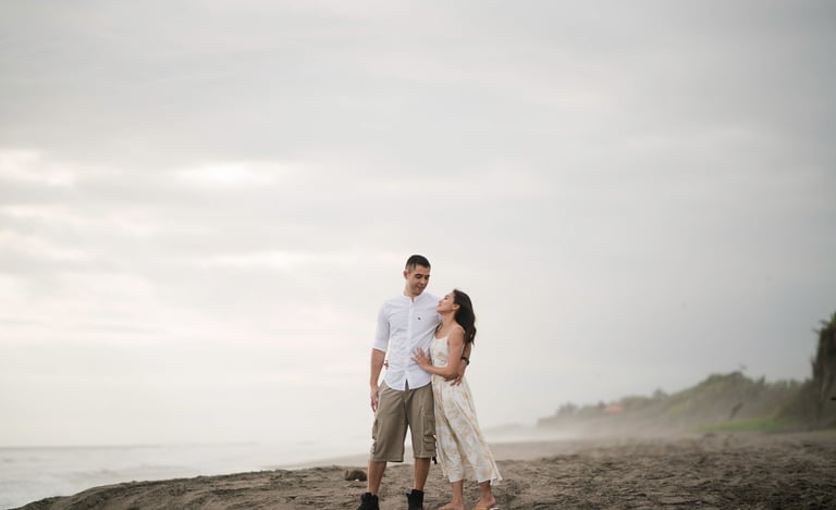 Couple walking along quiet beach at Waka Gangga Tabanan West Bali