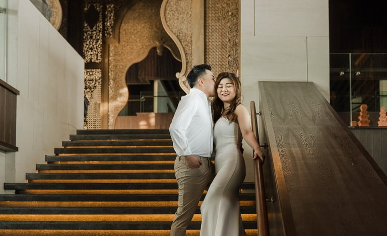 Couple standing on the iconic grand staircase during a prewedding photoshoot at Apurva Kempinski Bali