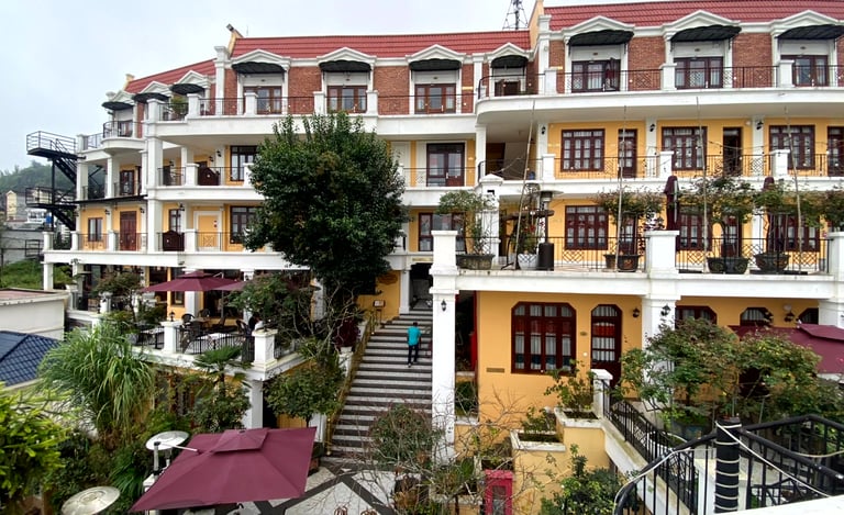a building with a staircase leading to a building with a red roof