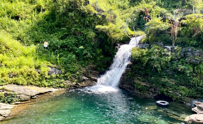 a man is standing in front of a waterfall